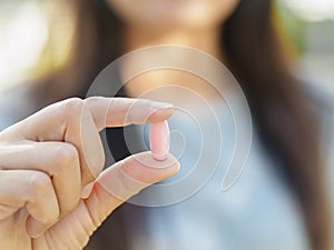 Close up of woman hand holding pills.