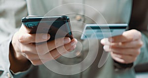 Close up of woman hand holding smartphone and credit card and doing online shopping at home