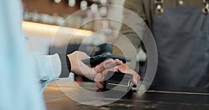 Close up of a woman hand holding a smartphone with an NFC payment technology used for paying for take away coffee in a