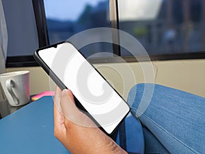 Close-up of a woman hand holding a smartphone white screen is blank .Mockup