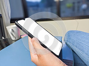 Close-up of a woman hand holding a smartphone white screen is blank .Mockup