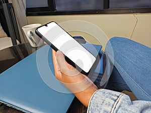 Close-up of a woman hand holding a smartphone white screen is blank .Mockup