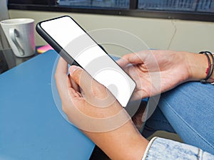 Close-up of a woman hand holding a smartphone white screen is blank .Mockup