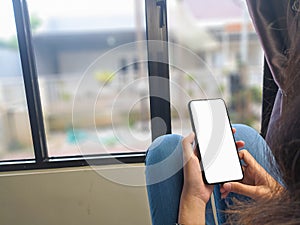 Close-up of a woman hand holding a smartphone white screen is blank .Mockup