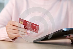 Close up of woman hand make payment online shopping by credit card via digital tablet