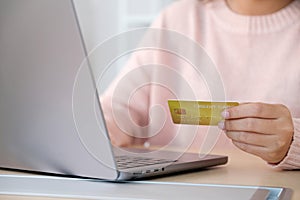 Close up of woman hand make payment online shopping by credit card via laptop computer