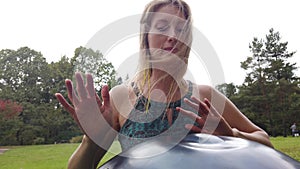 Close-Up Of woman Hand Playing On Modern Musical Instrument Hand Pan