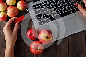 Close up of a woman hand plugging red pendrive on a laptop