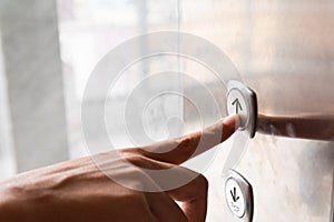 Close up woman hand press a up button of elevator