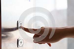 Close up woman hand press a up button of elevator