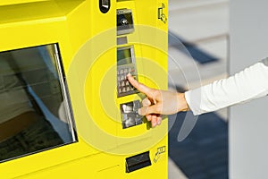 Close up of woman hand pressing button on automatic terminal machine