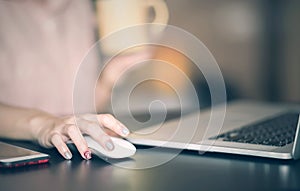 Close up of woman hand searching and click mouse using laptop