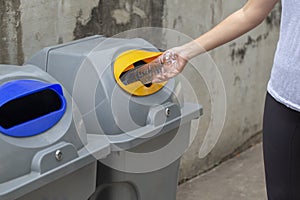 Close up woman hand throwing empty plastic bottle drop in recycling bin , Save the world concept