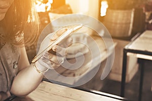 Close up woman hand typing message on smart phone in restaurant.