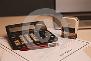 Close up woman hand using calculator and writing make note with calculate about cost at home office