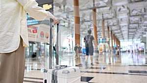 Close-up woman hand walking with suitcase , check in at International airport , vacation travel and transportation concept