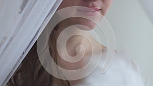 Close up woman hand waving with white feather fan on white background half face real people series. Hiding behind veil