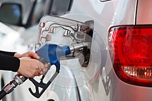 Close Up woman handle pumping gasoline fuel nozzle in tank for car at gas station