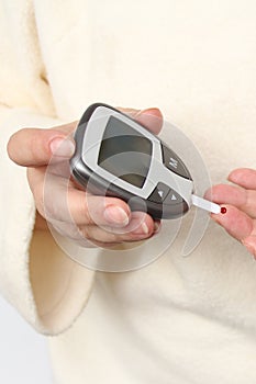 Close up of woman hands checking blood sugar level by Glucose meter for diabetes tester using as Medicine, glycemia, healthcare