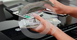 close-up of woman hands counting a stack of hundred-dollar US banknotes.