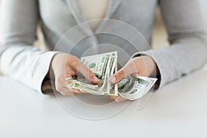 Close up of woman hands counting us dollar money