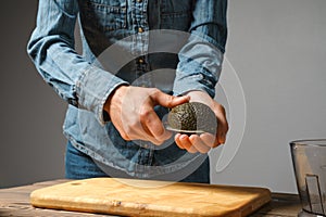 Close up of woman hands cutting fresh avocado with knife