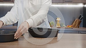 Close up of woman hands demonstrating new frying pans set for kitchen with a removable handle. Action. Concept of house