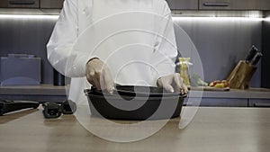 Close up of woman hands demonstrating new frying pans set for kitchen with a removable handle. Action. Concept of house