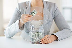 Close up of woman hands and dollar money in jar