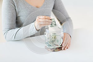 Close up of woman hands and dollar money in jar