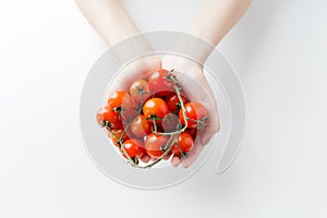 Close up of woman hands holding cherry tomatoes