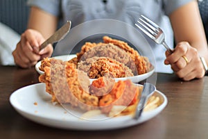 Close-up woman hands holding cutting fried.