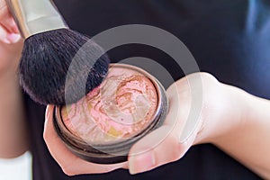 Close up of woman hands holding makeup bronzer