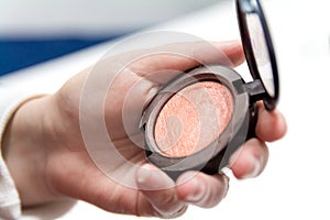 Close up of woman hands holding makeup brush and blush box