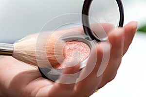 Close up of woman hands holding makeup brush and blush box