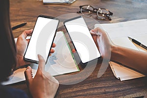 Close up of woman hands holding touching mobile phone with blank copy space white screen for your text message and glasses,books