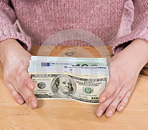 Close up of woman hands holding us dollar and euro money
