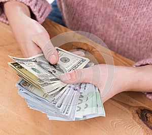 Close up of woman hands holding us dollar and euro money
