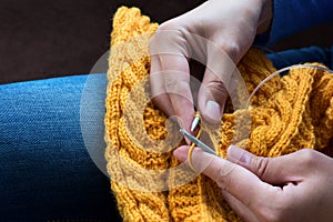 Close up of woman hands knitting colorful wool yarn