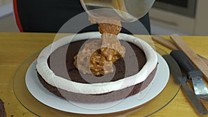 Close up of woman hands making sweet cake with white cream and biscuit.