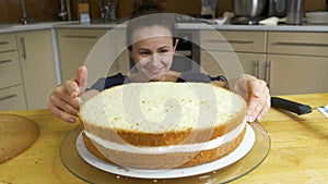 Close up of woman hands making sweet cake with white cream and biscuit.