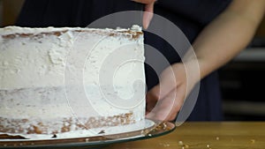 Close up of woman hands making sweet cake with white cream and biscuit.Close up of woman hands making sweet cake with white cream