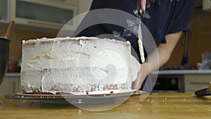 Close up of woman hands making sweet cherry cake with white cream and biscuit.