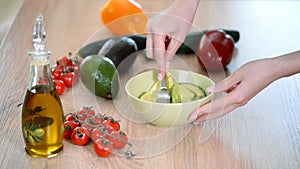 Close-up Of Woman Hands Mashing Avocado With Fork In Bowl.