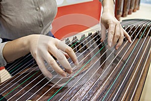 Close up of woman hands playing the Chinese traditional stringed instrument guzheng