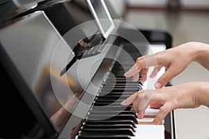 Close up of woman hands playing piano on background