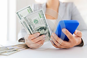 Close up of woman hands with smartphone and money