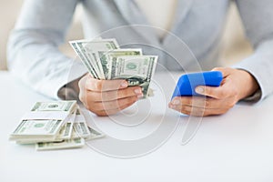 Close up of woman hands with smartphone and money