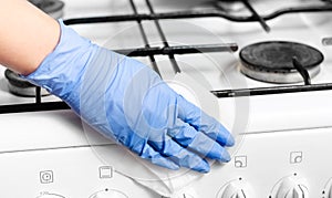 Close-up of  woman hands with surgical gloves cleaning the coocking stove  of grease and dirt