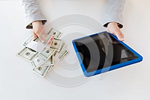 Close up of woman hands with tablet pc and money